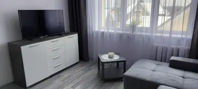 a living room with a dresser with a tv and a couch at Pas Olia 2 in Zarasai