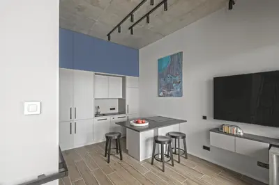 a kitchen with a bar with stools and a tv at IVIS House Modern Apartment in Vilnius Old Town with balcony in Vilnius