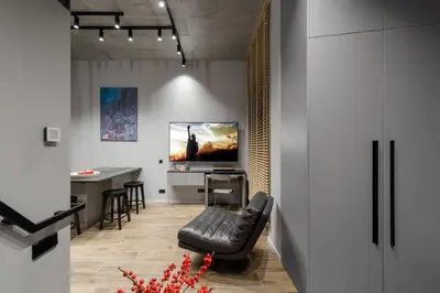 a living room with a black leather chair and a table at IVIS House Modern Apartment in Vilnius Old Town with balcony in Vilnius