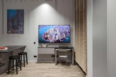 a living room with a television on a desk at IVIS House Modern Apartment in Vilnius Old Town with balcony in Vilnius