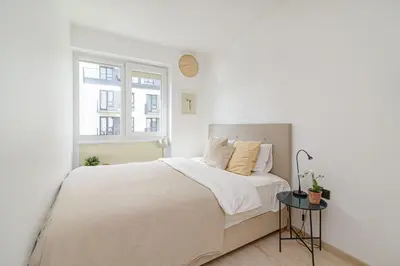 a white bedroom with a bed and a window at Modern Apartment Next to Ozas park by URBAN RENT in Vilnius