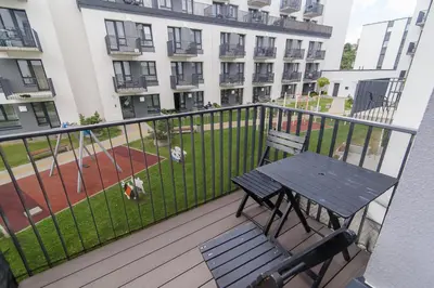 a deck with a table and a bench on a balcony at Modern Apartment Next to Ozas park by URBAN RENT in Vilnius