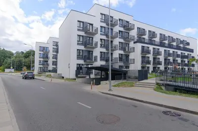 a large white building on the side of a street at Modern Apartment Next to Ozas park by URBAN RENT in Vilnius
