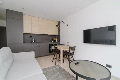 a living room with a white couch and a table at Modern Apartment Next to Ozas park by URBAN RENT in Vilnius