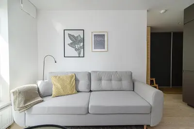 a living room with a gray couch in a room at Modern Apartment Next to Ozas park by URBAN RENT in Vilnius