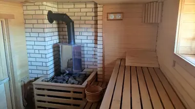a sauna with a wood stove in a room at Padvarių sodyba ant tvenkinio kranto su pirtimi in Šiupieniai