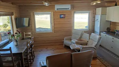 a kitchen and dining room with a table and chairs at Padvarių sodyba ant tvenkinio kranto su pirtimi in Šiupieniai