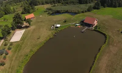 an aerial view of a house next to a lake at Padvarių sodyba ant tvenkinio kranto su pirtimi in Šiupieniai