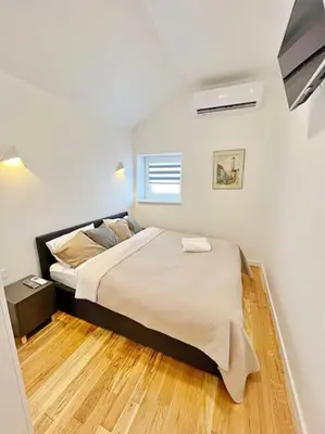 a bedroom with a large bed and wooden floors at White 1 BD Old Town Apartment by Hostlovers in Kaunas