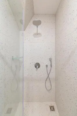 a shower with a glass door in a bathroom at White 1 BD Old Town Apartment by Hostlovers in Kaunas