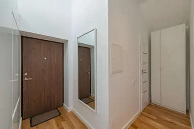 a hallway with a door and a mirror at White 1 BD Old Town Apartment by Hostlovers in Kaunas