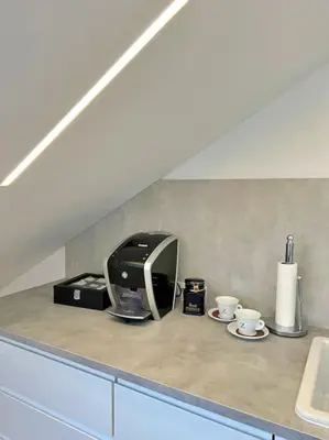a kitchen counter with a toaster and two coffee cups at White 1 BD Old Town Apartment by Hostlovers in Kaunas