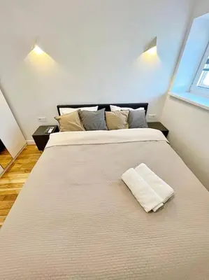 a large bed with a white pillow on top of it at White 1 BD Old Town Apartment by Hostlovers in Kaunas