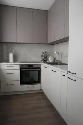 a kitchen with white cabinets and a black oven at Luxuria Modern Apartments - Self Check-in in Šiauliai