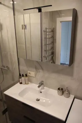 a bathroom with a sink and a mirror at Luxuria Modern Apartments - Self Check-in in Šiauliai