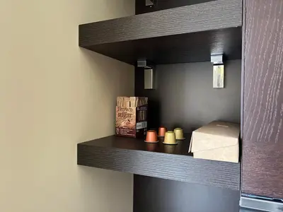 a book shelf with a bed and candles on it at Luxuria Modern Apartments - Self Check-in in Šiauliai