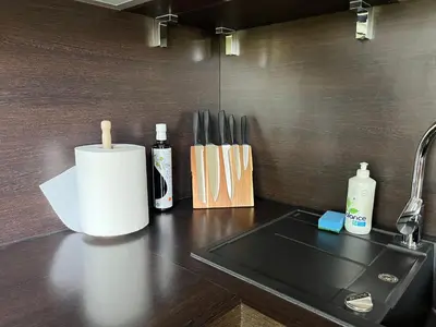 a kitchen counter with a knife block and a sink at Luxuria Modern Apartments - Self Check-in in Šiauliai