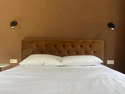 a bed with white sheets and pillows in a bedroom at Luxuria Modern Apartments - Self Check-in in Šiauliai