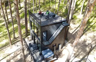 an aerial view of a tree house in the woods at Premium Forest Bungalow with HOT TUB in Ažuluokesa