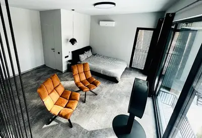 a living room with two chairs and a bed at Premium Forest Bungalow with HOT TUB in Ažuluokesa