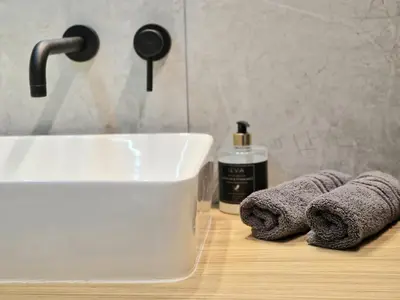 a bathroom sink with two towels and a bottle of soap at Cozy Apartment with panoramic view in Anykščiai