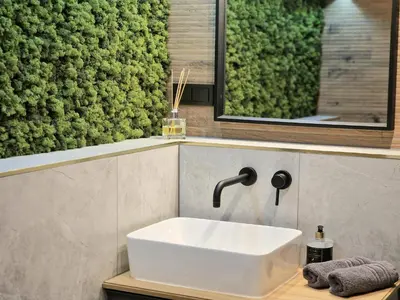 a bathroom with a sink and a green wall at Cozy Apartment with panoramic view in Anykščiai