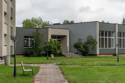 a building with two benches in front of it at Cozy Apartment with panoramic view in Anykščiai
