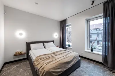 a bedroom with a bed and a large window at Oldtown Trinity House in Kaunas