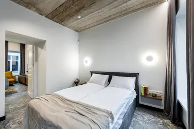 a bedroom with a large bed with white sheets at Oldtown Trinity House in Kaunas