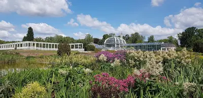 a garden with flowers in front of a glass house at Oldtown Trinity House in Kaunas