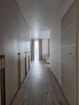 a long hallway with white walls and wooden floors at Life Story in Kaunas