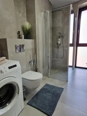 a bathroom with a shower and a washing machine at Life Story in Kaunas