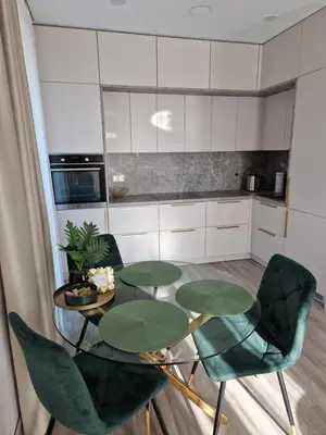 a kitchen with four green chairs and a table at Life Story in Kaunas