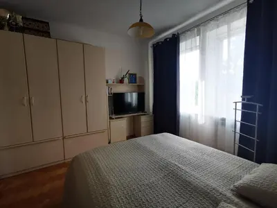 a bedroom with a bed and a tv and a window at Spacious Apartment with free parking in Kaunas in Kaunas