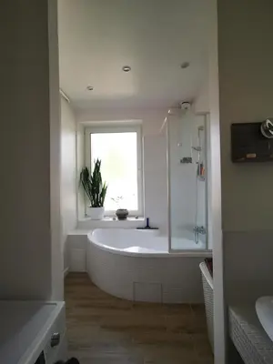 a white bathroom with a tub and a window at Spacious Apartment with free parking in Kaunas in Kaunas