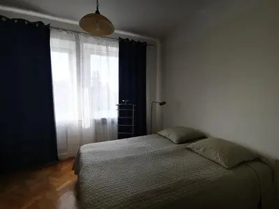 a bedroom with a bed and a large window at Spacious Apartment with free parking in Kaunas in Kaunas
