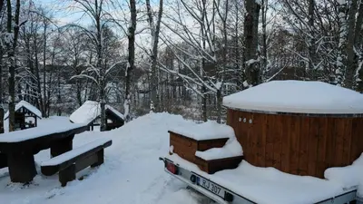 a snow covered bin in a yard with trees at Namelis Šiaurėje in Kaltanėnai