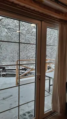 a window with a view of a snow covered yard at Namelis Šiaurėje in Kaltanėnai