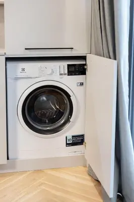 a washing machine in a room with a curtain at Renaissance Key Apartment 29 in Vilnius