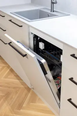 a dishwasher in a white kitchen with a sink at Renaissance Key Apartment 29 in Vilnius