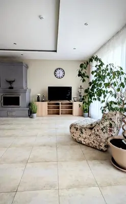 a living room with a couch and a clock on the wall at Baltamiškio slėnis in Baltamiškis