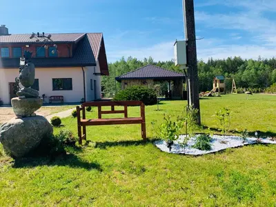 a park with a bench and a fountain in the grass at Baltamiškio slėnis in Baltamiškis