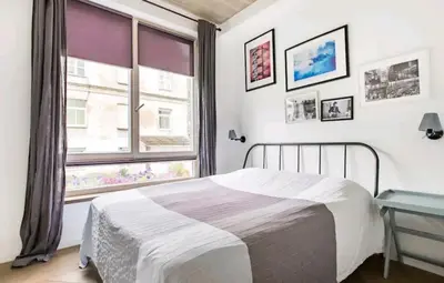 a bedroom with a bed and a large window at Free Indoor Parking Old Town Basanavičius Park & Balcony in Vilnius