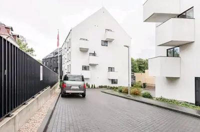 a van driving down a street next to a white building at Free Indoor Parking Old Town Basanavičius Park & Balcony in Vilnius