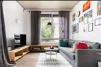 a living room with a gray couch and a table at Free Indoor Parking Old Town Basanavičius Park & Balcony in Vilnius