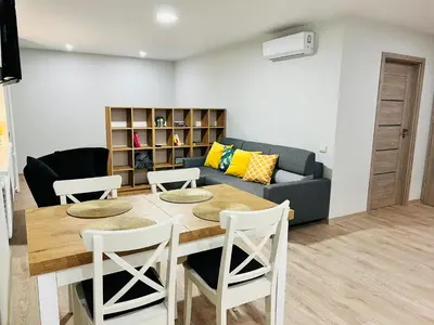 a living room with a table and chairs and a couch at Saulėti apartamentai Trakuose/Sunny apartment in Trakai in Trakai