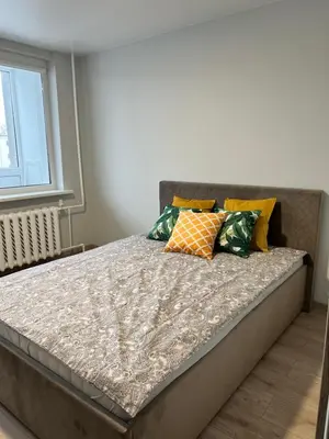 a bed with colorful pillows on it in a bedroom at Saulėti apartamentai Trakuose/Sunny apartment in Trakai in Trakai