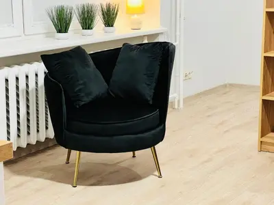 a black leather chair sitting in a room at Saulėti apartamentai Trakuose/Sunny apartment in Trakai in Trakai