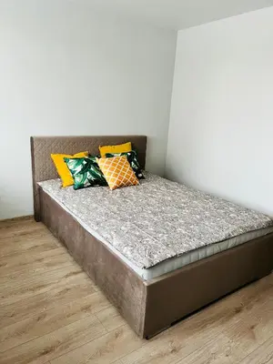 a bed with four pillows on it in a room at Saulėti apartamentai Trakuose/Sunny apartment in Trakai in Trakai