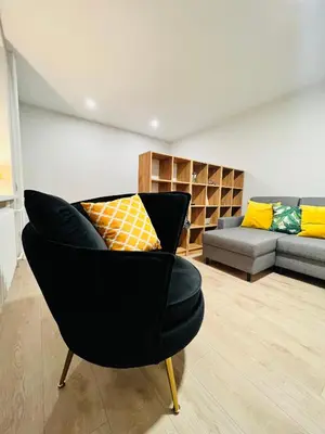 a living room with a black chair and a couch at Saulėti apartamentai Trakuose/Sunny apartment in Trakai in Trakai